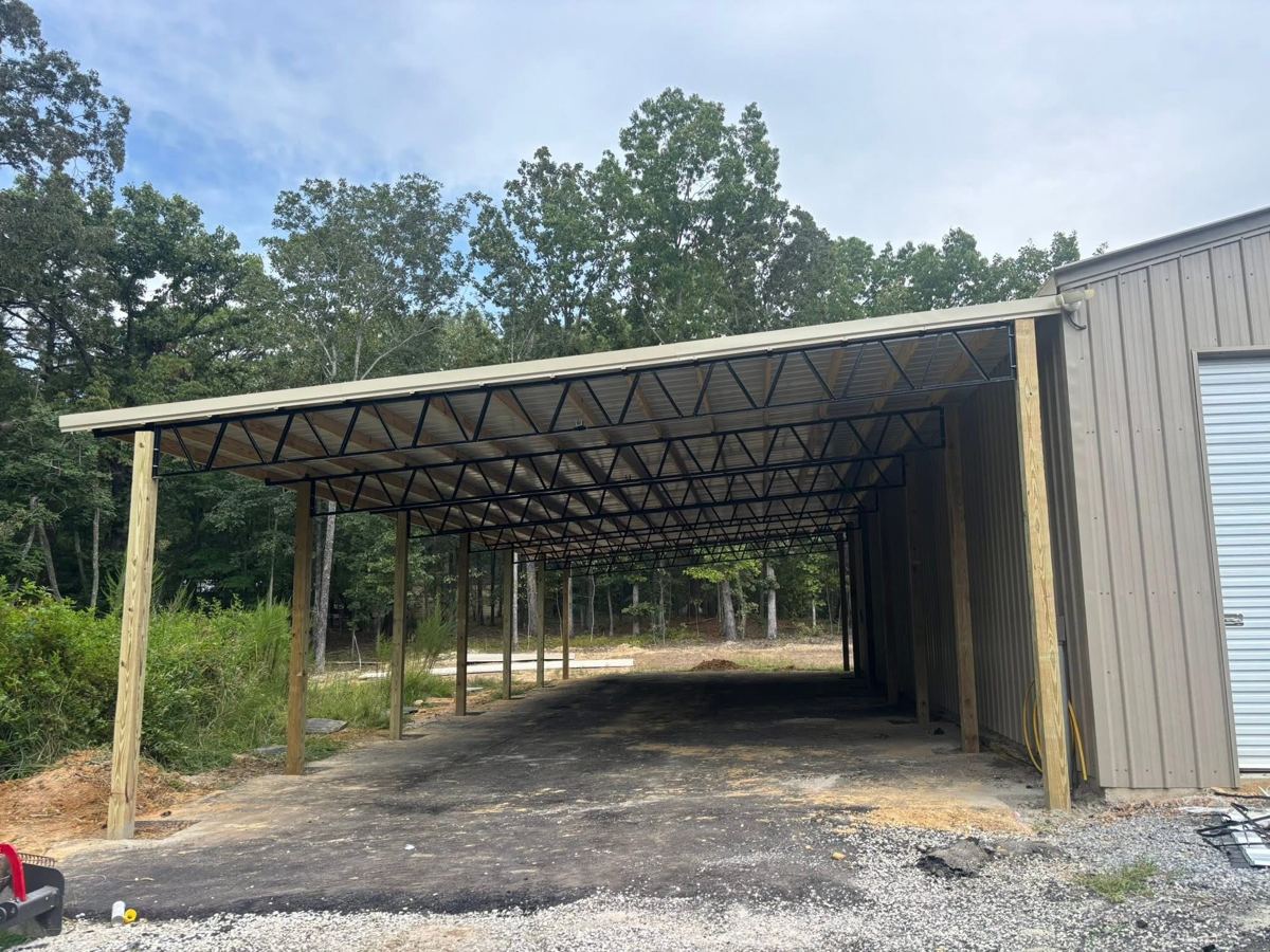 A long open pole barn next to a metal building