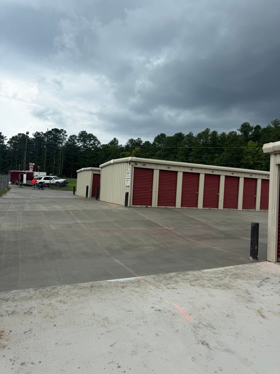 Rows of storage units with red doors on a concrete drive
